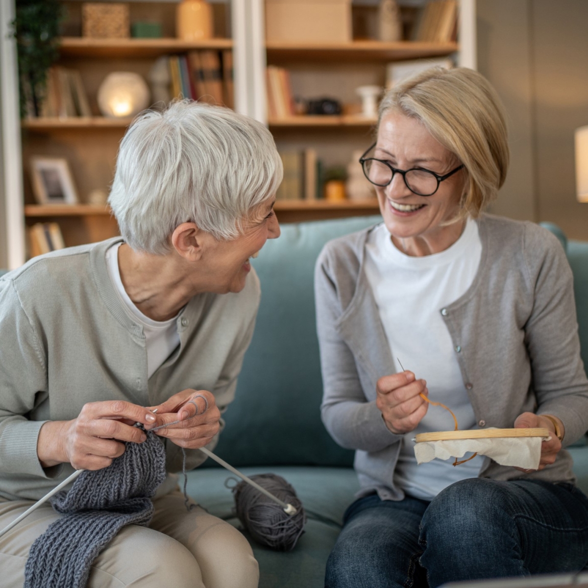 two older women doing needlework, one wearing glasses