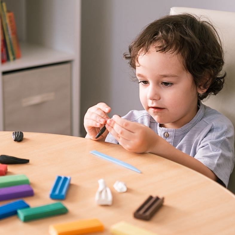 Child playing with craft dough at a table