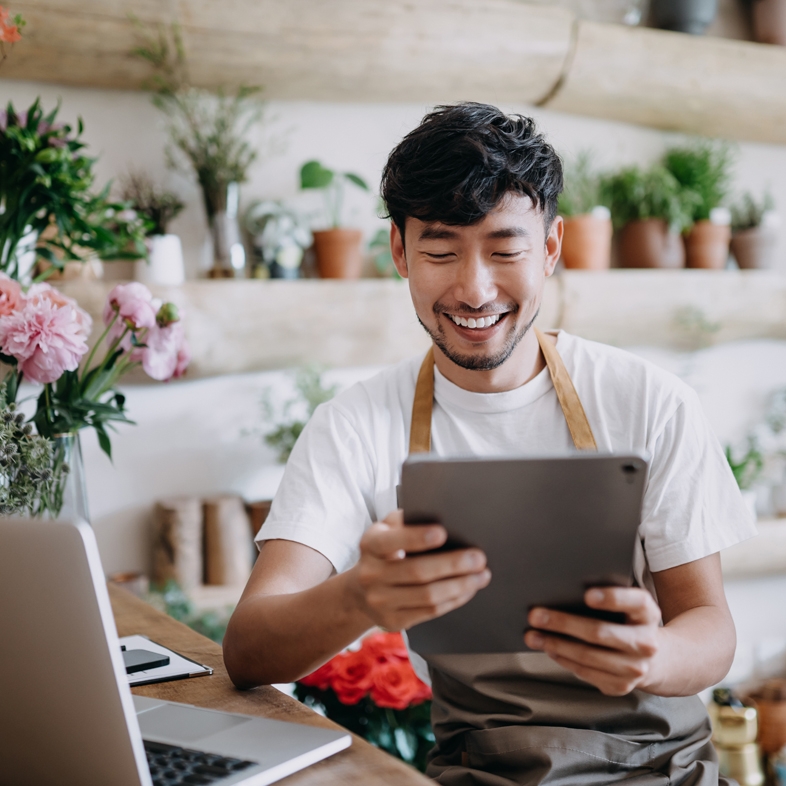 Business owner in flower shop looking at tablet