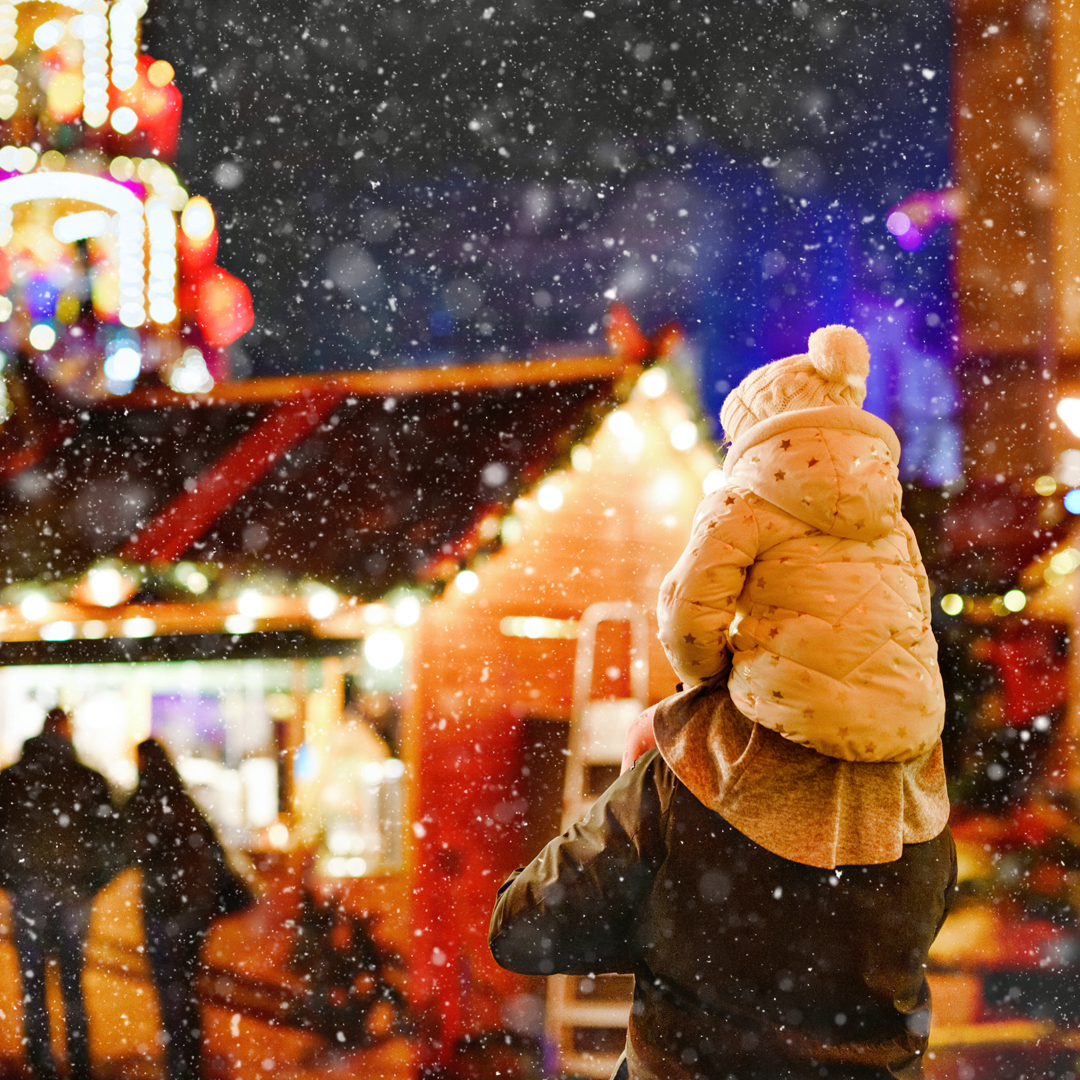 Child on adult's shoulders walking in the snow