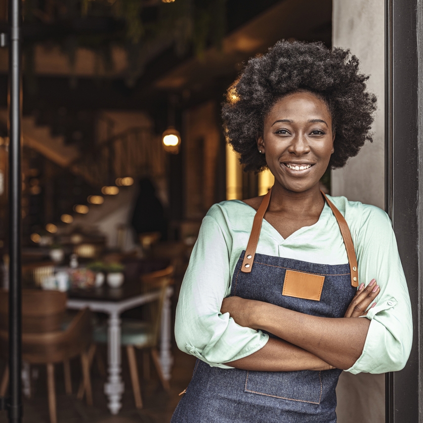 Woman with arms crossed wearing an apron