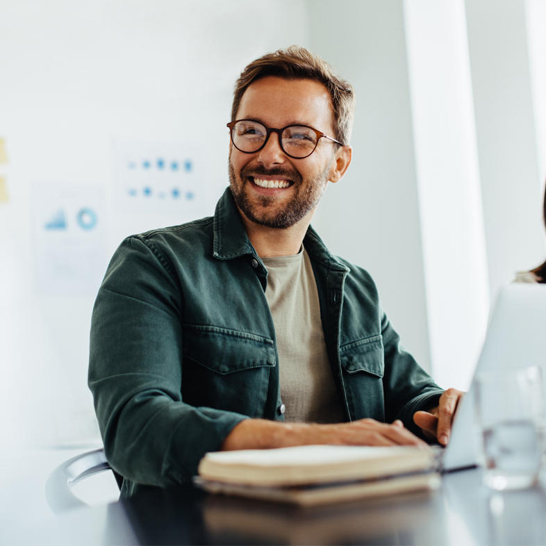 Man looking over smiling at a table